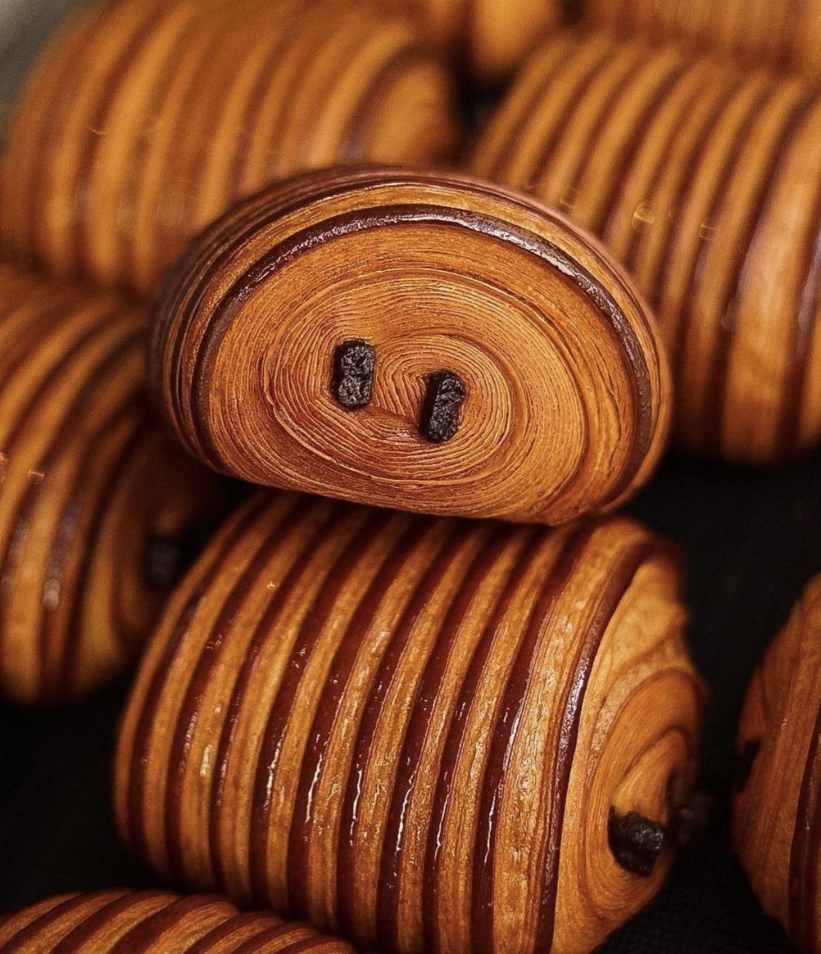 A croissant with swirls going to the center and two dots in the center resembling eyes, overall resembling the look of a fire flower without the stem.